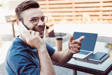 el hareketi ve smartphone tarafından sokak café'de konuşuyor yakışıklı adam gülümseyen