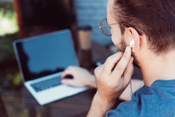 side view of handsome man taking part in webinar with laptop