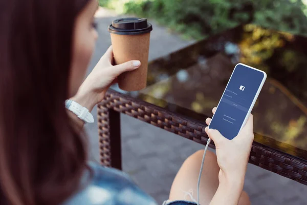 Kobieta Pomocą Smartfona Facebook Urządzenia Przy Stole Przytrzymując Kawy Papier — Zdjęcie stockowe