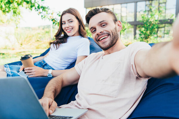 камера с точки зрения улыбающихся коллег, участвующих в вебинаре на креслах из бобов в парке
