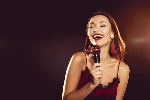 portrait of seductive woman with microphone in hand singing karaoke 