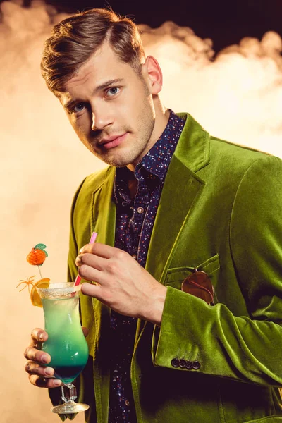 yeşil ceketli kokteyl ile cam duman ile parti üzerinde tutarak yakışıklı çekici adamı