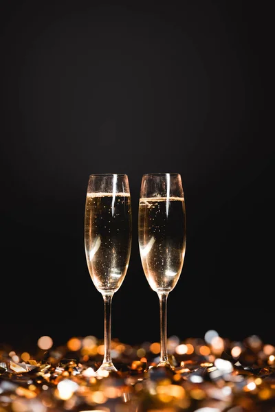 新年庆祝与香槟杯子在金黄五彩纸屑在黑色 — 图库照片