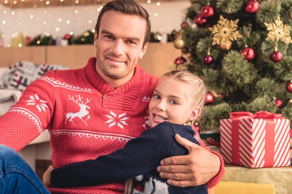 Father Hugging Adorable Daughter Christmas Tree Home Looking Camera — Stock Photo, Image