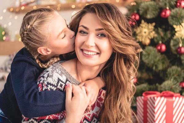 Adorable Daughter Kissing Smiling Mother Christmas Tree Home — Stock Photo, Image