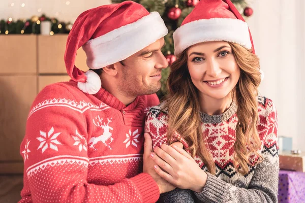 Sonrientes Marido Mujer Sombreros Santa Cogidos Mano Cerca Del Árbol — Foto de Stock