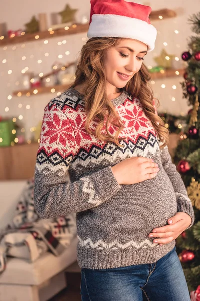 Attractive Pregnant Woman Santa Hat Touching Belly Home — Stock Photo, Image