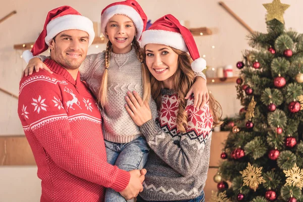 Smiling Parents Santa Hats Holding Daughter Looking Camera Home — Stock Photo, Image