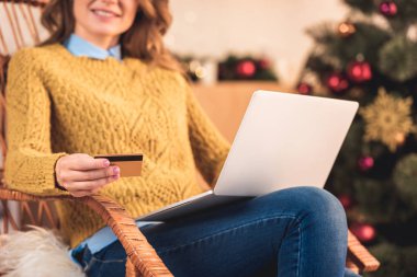 kredi kartı ve dizüstü bilgisayar ile Noel alışveriş online kadının kırpılmış görünümü