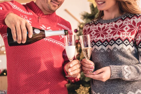 Ausgeschnittene Ansicht Von Paar Weihnachtspullis Ehemann Gießt Champagner Für Frau — Stockfoto