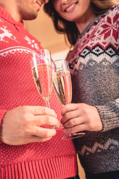 Cropped View Couple Christmas Sweaters Clinking Champagne Glasses — Free Stock Photo