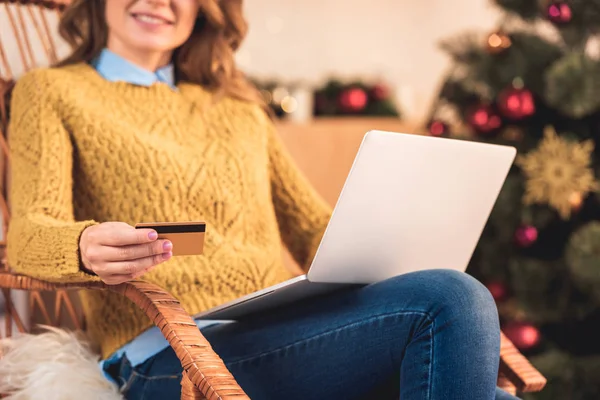 在圣诞节的信用卡和笔记本电脑的妇女在线购物的裁剪视图 — 图库照片