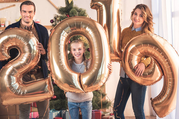 happy family with daughter holding 2019 new year golden balloons 