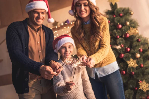 Família Feliz Com Filha Chapéus Santa Segurando Sparklers Casa Com — Fotografia de Stock