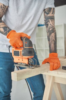 atış dövmeli gencin elektrikli testere kullanarak kırpılmış  