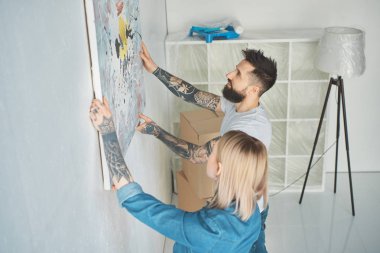 resim yeni daire duvara asılı dövmeli genç çift yan görünüm