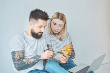 Genç çift renk paletinde yeni evde birlikte seçme dizüstü bilgisayar ile