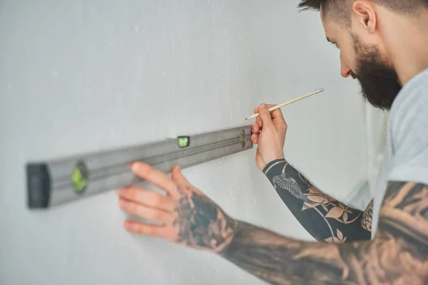 Cropped Shot Handsome Bearded Young Man Holding Level Tool Pencil — Free Stock Photo