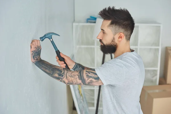 Side View Bearded Young Man Hammering Nail Wall — Stock Photo, Image