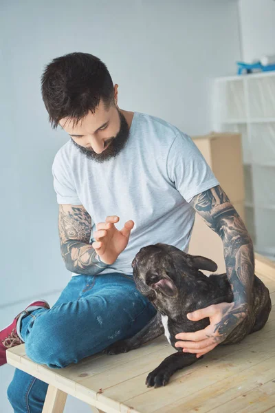 Tatuado Homem Jogar Com Francês Bulldog Superfície Madeira Novo Apartamento — Fotografia de Stock Grátis