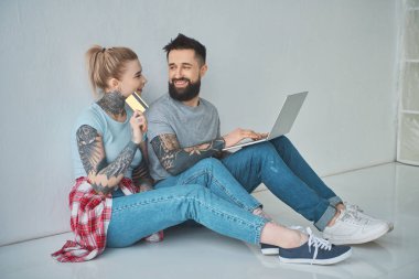 dizüstü bilgisayar ve kredi kartı alışveriş online yeni evinde ile çift gülümseyen
