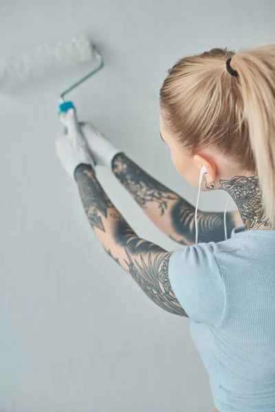 Vista Trasera Mujer Tatuada Auriculares Pintando Pared Nuevo Hogar — Foto de stock gratis