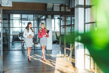 Koridorda yürürken konuşmayı genç iş kadınları