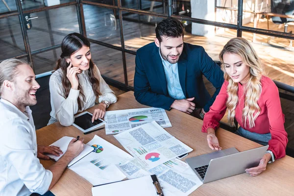 Yeni iş projesi kağıtları ve office içinde laptop ile işyerinde tartışırken iş takım