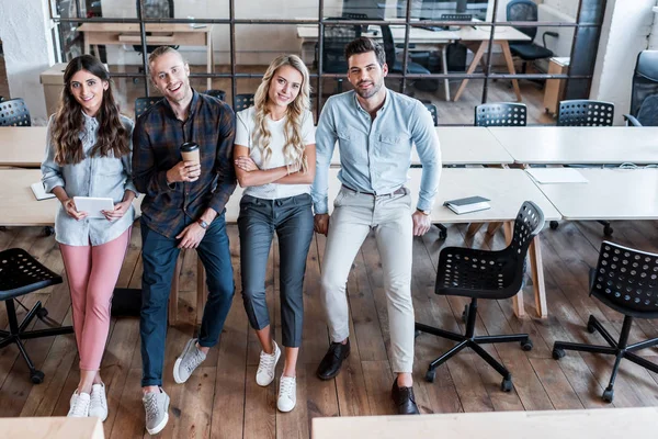 Vista Ángulo Alto Cuatro Jóvenes Colegas Negocios Sentados Las Mesas — Foto de Stock