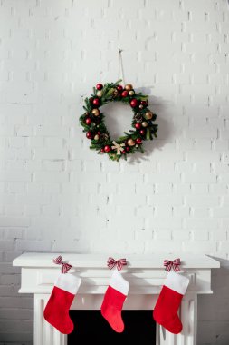 Noel çorap ve köknar çelenk ile tuğla duvar odadaki asılı baubles ile şömine