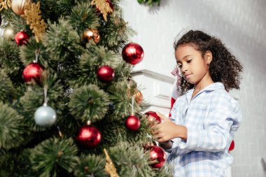 çok güzel Afro-Amerikan çocuk pijama kırmızı topları evde ile Noel ağacı süsleme
