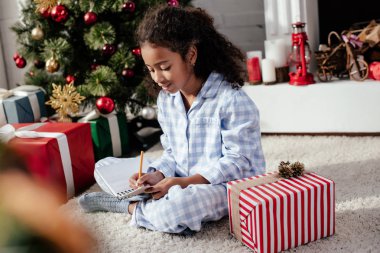 çok güzel Afro-Amerikan çocuk pijama bir şey için defterini evde, Noel kavramı yazma