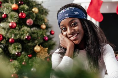 gülümseyen çekici Afrikalı-Amerikalı kadın evde, kameraya Noel kavramı arıyorsunuz