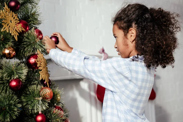 Side View Adorable African American Child Pajamas Decorating Christmas Tree — Stock Photo, Image