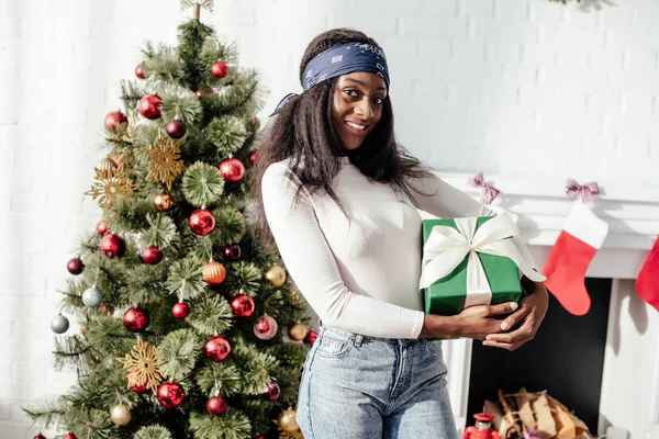 Alegre Atraente Mulher Afro Americana Segurando Natal Presente Casa Olhando — Fotografia de Stock