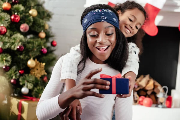 Glückliche Afrikanisch Amerikanische Tochter Schenkt Mutter Hause Ein Weihnachtsgeschenk — Stockfoto