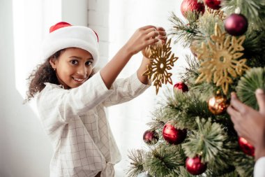 Afrikalı-Amerikalı kadın ve çocuk evde birlikte Noel ağacı süsleme kısmi görünümünü