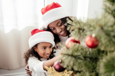 Noel Baba'ya mutlu Afro-Amerikan aile portresi dekorasyon Noel ağacı birlikte evde şapka