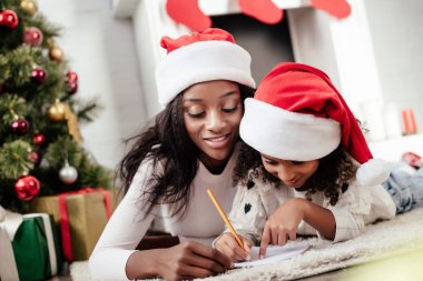 Afrika kökenli Amerikalı Anne yardım kız evde Noel Baba'yı mektup yazmaya