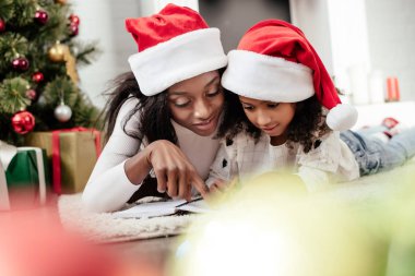 Afrika kökenli Amerikalı Anne yardım kız evde Noel Baba'yı mektup yazmaya