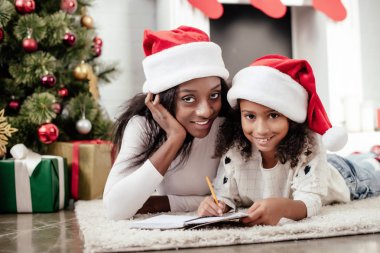 Afrika kökenli Amerikalı Anne yardım kız evde Noel Baba'yı mektup yazmaya