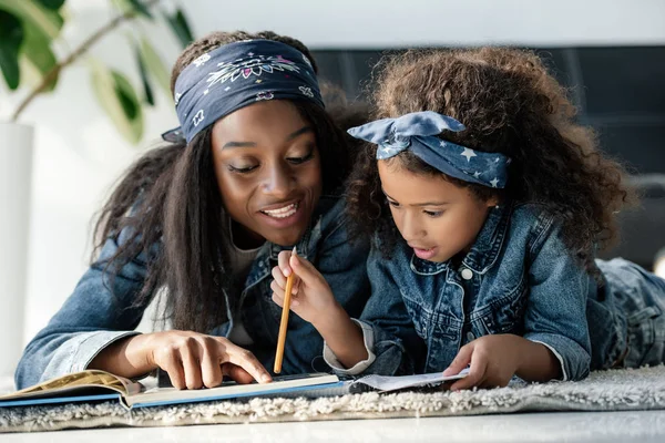 非洲裔美国人妇女帮助女儿在家做家庭作业的肖像 — 图库照片