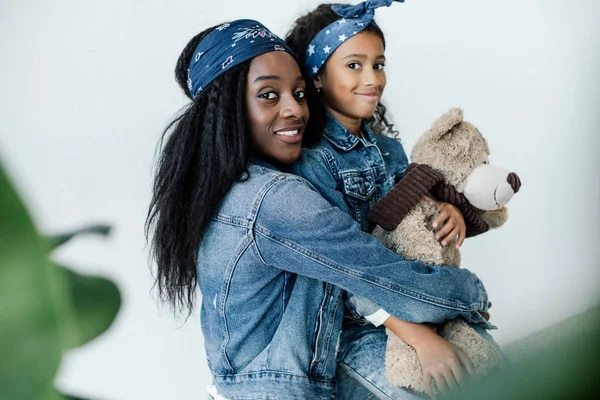 Portret Wesoły African American Kobieta Przytulanie Córeczkę Misiem Domu — Darmowe zdjęcie stockowe
