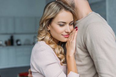 boyfriend cuddling attractive girlfriend in kitchen clipart