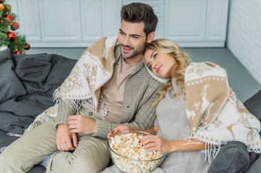 evde film izlerken patlamış mısır ile güzel genç çiftin yüksek açılı görünüş