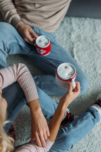 Cropped Image Couple Sitting Carpet Holding Cups Cappuccino Home Christmas — Stock Photo, Image