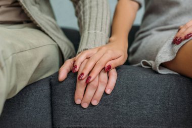 birlikte kanepede otururken çift sevgi tutuşup kırpılmış atış