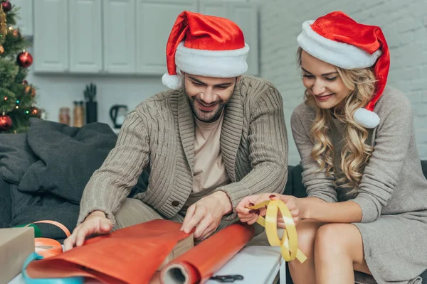 Attrayant Jeune Couple Dans Chapeaux Santa Décoration Cadeau Noël Ensemble — Photo