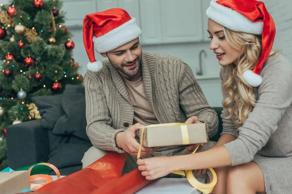 Pareja Joven Sombreros Santa Decoración Regalo Navidad Juntos Casa — Foto de stock gratis