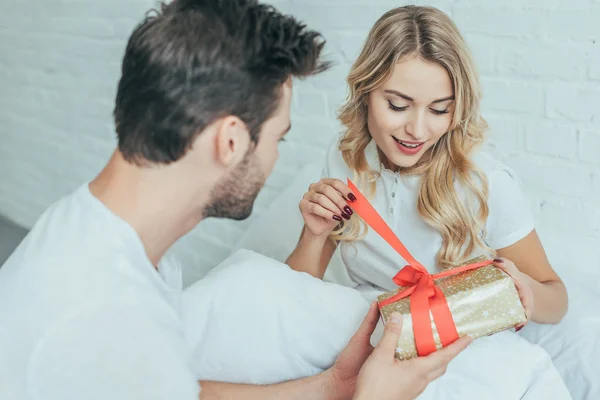 Handsome Young Man Presenting Gift Girlfriend Bed Home — Stock Photo, Image